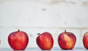 Row of three apples with one that is imperfect